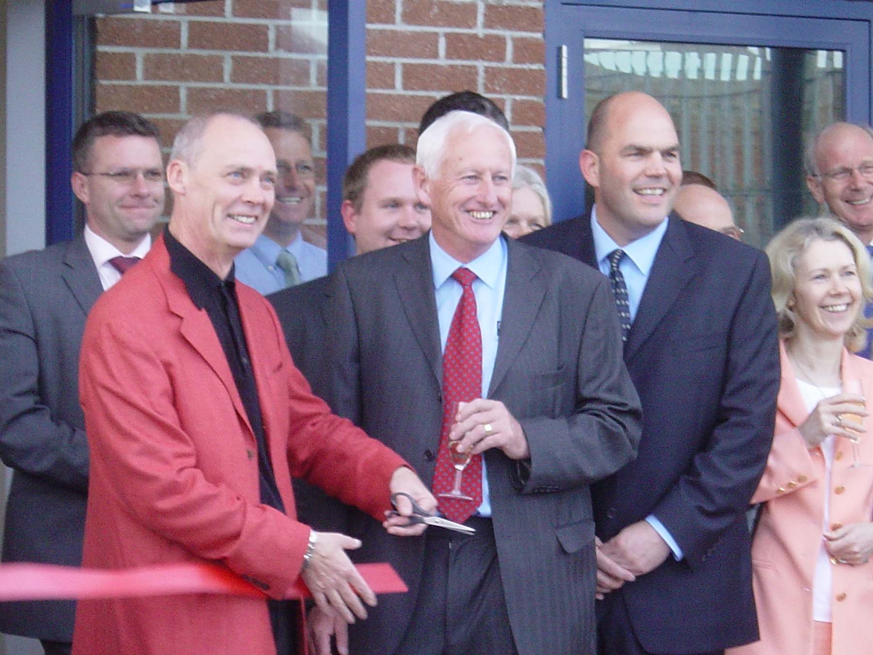 Grapevine staff and guests cut a red ribbon at the opening of our Poole Office.